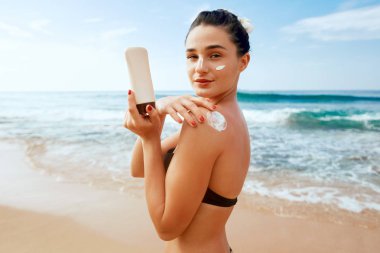 Bikini Güzel Kadın Tabaklanmış Omuz Güneş Kremi Uygulayarak. Güneş koruma. Cilt ve Vücut Bakımı. Cilt için Güneş Kremi Kullanarak Kız. Kadın Holding Suntan Losyonu ve Nemlendirici Güneş Kremi Portresi.