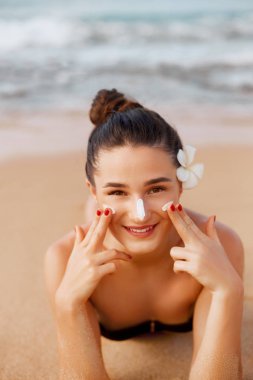 Suntan Losyonu. Bikini Güneş Koruyucu Güneş Kremi.Sun Protection Uygulayarak Güzellik Seksi Genç Kadın. Güneş kremi. Cilt ve Vücut Bakımı.Nemlendirici Güneş Kremi Tutan Kız. Omzunda güneş şekli. Cilt Koruma