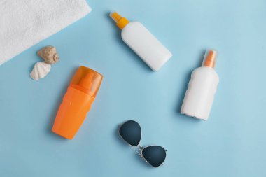 Güneş kremi, krem, güneşlik şişesi, Güneş kremi, losyon şişesi, deniz kabukları. Plaj düz aksesuarlar yatıyordu. Yaz seyahati tatil konsepti. Summertime tatil