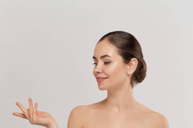 Kadın sürpriz ürün gösteren . Güzel kız ifade yana işaret ediyor. Reklamınızı sunuyor. Etkileyici yüz ifadeleri