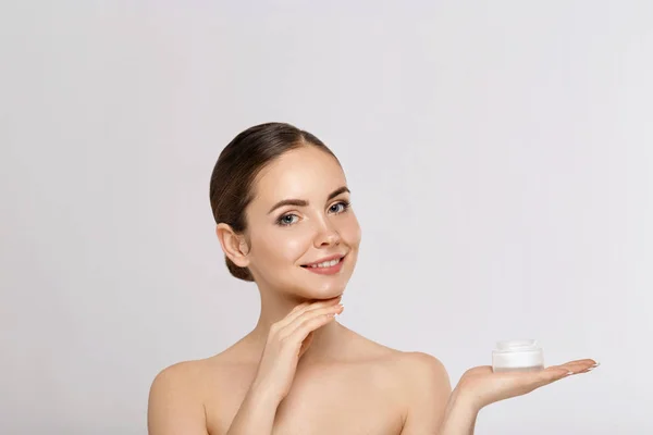 Kadın Kavramının Güzellik Yüzü. Cilt bakımı. Kadın modeli tutma ve kozmetik nemlendirici krem ve dokunmatik kendi yüzü uygulayarak Portresi. Cilt Koruma. Kozmetoloji. Spa