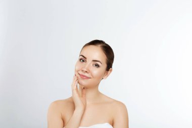 Temiz ciltli güzel bir genç kadın. Doğal çıplak makyajlı ve yüzüne dokunan güzellik modeli portresi. Spa, cilt bakımı ve sağlık. Yakın çekim, kopyalanma alanı.