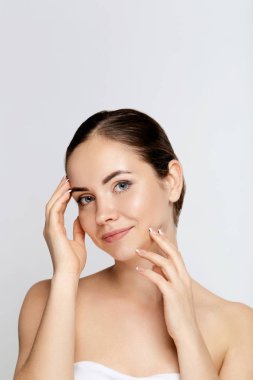 Güzellik ve Spa Konsepti. Temiz Taze Cilt dokunmatik kendi yüzüne sahip Güzel Genç Kadın. Yüz bakımı. Doğal Makyaj.Cosmetology ile Kız Kadın. Cilt bakımı. Kozmetik