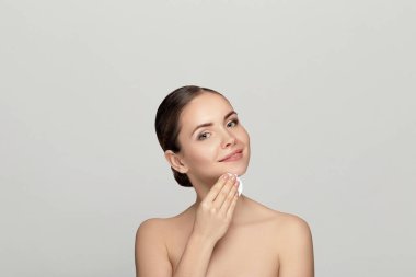 Pamuk yastıkla makyajı kesen neşeli, genç bir kadının güzel portresi. 