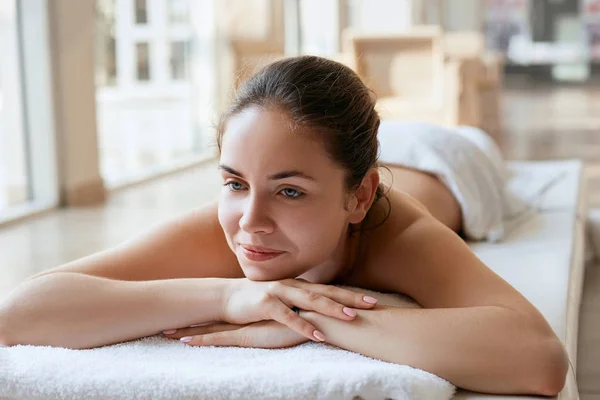 Beautiful, young and healthy woman in spa salon. Spa, health and healing concept. Massage treatment  on light background.