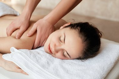 Masaj. Spa salonunda dinlenen güzel kadın. Vücut bakımı. Spa gövdesi. Kozmetoloji. Spa salonunda masaj yaptıran kız