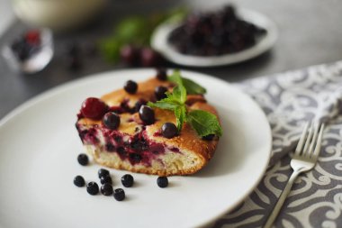 Beyaz bir tabak, peçete tatlı için yaban mersini, rasberry ve nane ile pasta Parçası. Lezzetli ev yapımı kek parçaları