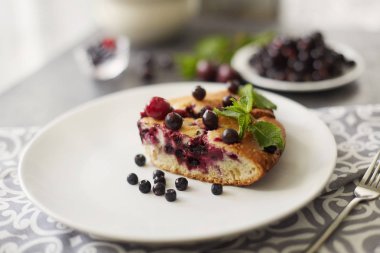 Beyaz bir tabak, peçete tatlı için yaban mersini, rasberry ve nane ile pasta Parçası. Lezzetli ev yapımı kek parçaları