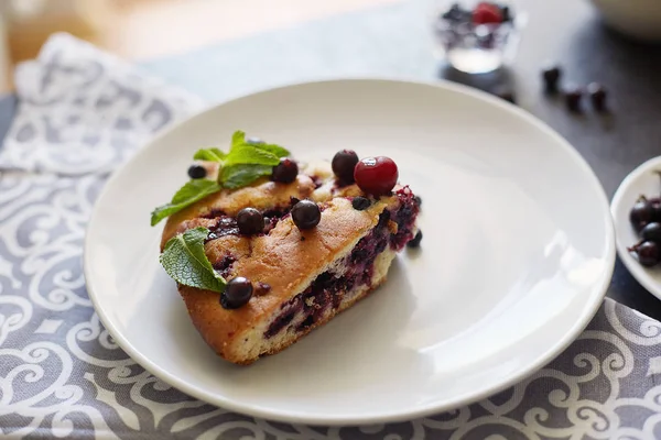 Beyaz bir tabak, peçete tatlı için yaban mersini, rasberry ve nane ile pasta Parçası. Lezzetli ev yapımı kek parçaları
