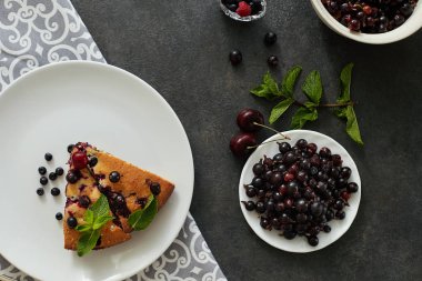 Beyaz bir tabak, peçete tatlı için yaban mersini, rasberry ve nane ile pasta Parçası. Lezzetli ev yapımı kek parçaları