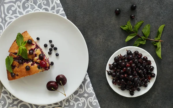 Beyaz bir tabak, peçete tatlı için yaban mersini, rasberry ve nane ile pasta Parçası. Lezzetli ev yapımı kek parçaları