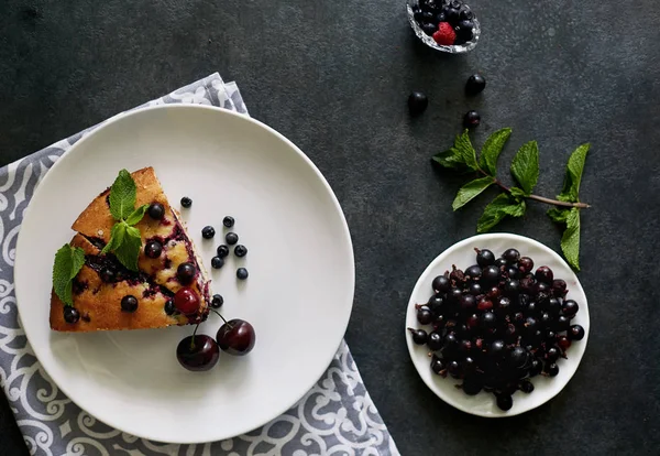 Beyaz bir tabak, peçete tatlı için yaban mersini, rasberry ve nane ile pasta Parçası. Bir arka plan üzerinde lezzetli ev yapımı kek Parçaları