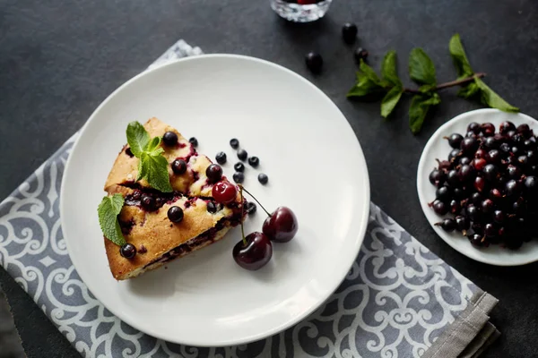 Beyaz bir tabak, peçete tatlı için yaban mersini, rasberry ve nane ile pasta Parçası. Bir arka plan üzerinde lezzetli ev yapımı kek Parçaları