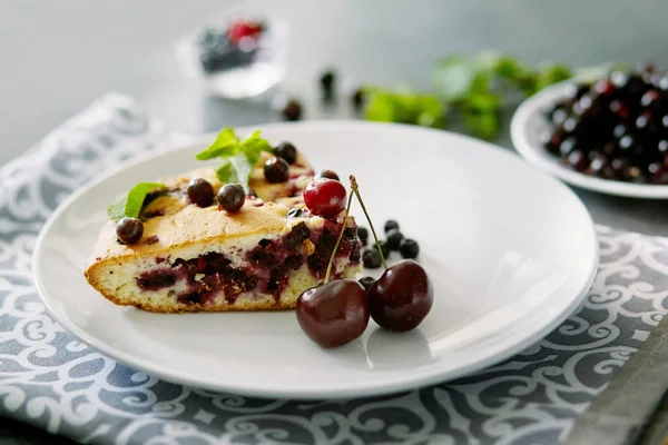 Beyaz bir tabak, peçete tatlı için yaban mersini, rasberry ve nane ile pasta Parçası. Bir arka plan üzerinde lezzetli ev yapımı kek Parçaları