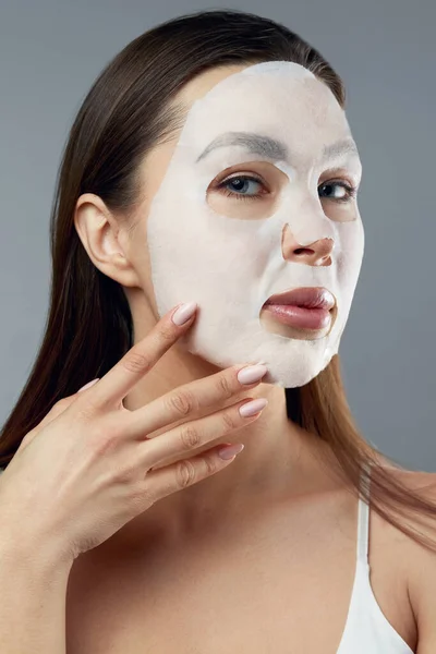 美容美发面具 漂亮的女人 脸上戴着布润肤面罩 化妆品水疗面具 面部治疗 — 图库照片