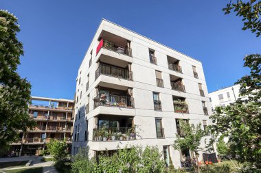 Şehrin yeni bir yerleşim bölgesinde modern apartman binaları, inşaat endüstrisi, emlak acentesi ve apartman satışları kavramı