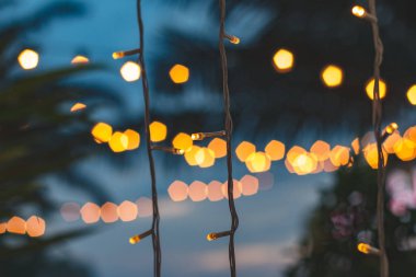 gün batımı, sarı dize ışıkları açık restoranda bokeh dekor ile Hindistan cevizi hurma ağacı arka plan ile bulanık ışık bokeh.