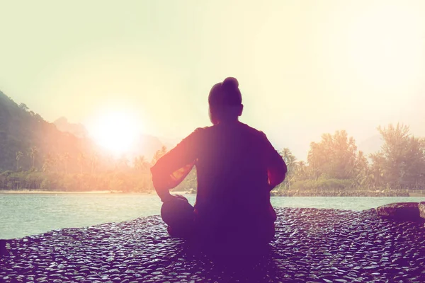 Silhouette of woman meditating with sunrise at the sea — Stock Photo, Image