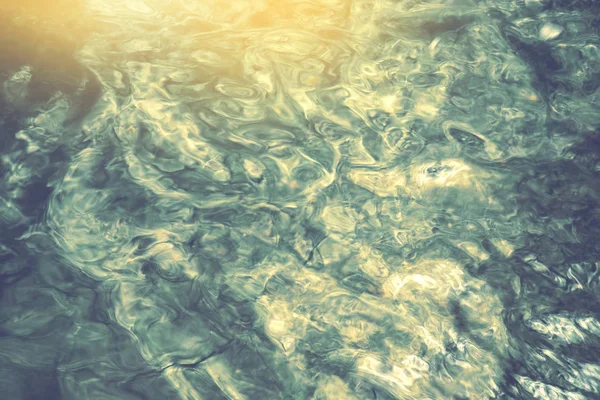 Reflejo de la luz solar de la ondulación en el océano, flujo borroso abstracto de fondo de agua — Foto de Stock