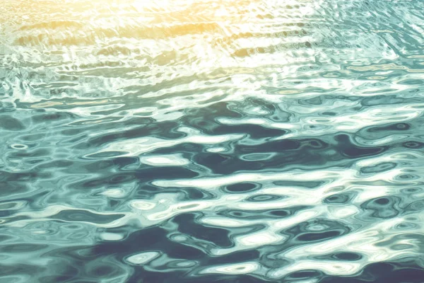 Superficie de agua borrosa abstracta del mar con luz solar amarilla — Foto de Stock