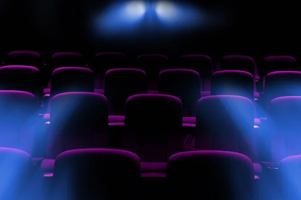 Cinema vazio com assentos roxos com raios de luz de clarão do projetor Imagens Royalty-Free