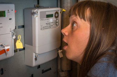 Korkmuş kadın elektrik sayacı - tüketimi ve pahalı elektrik kavramı denetliyor