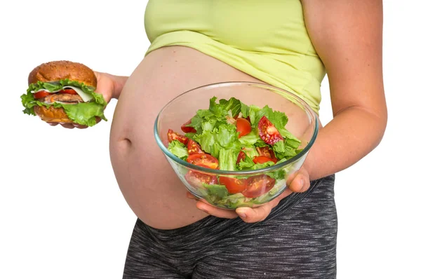 怀孕妇女与汉堡和蔬菜沙拉在她的手 在白色背景隔离 — 图库照片