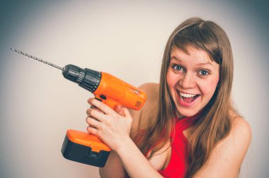 Gri arka plan - retro tarzı üzerinde matkap aracıyla güzel genç kadın