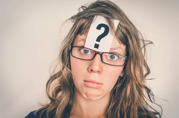 Woman is looking for a solution to the problem with question mark on paper over her forehead - retro style