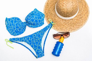 Hasır şapka, güneş gözlüğü, mayo ve beyaz arka plan üzerinde - tatil kavramı izole güneş kremi üstten görünüm 