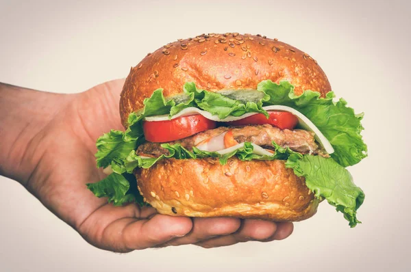 American burger in hand isolated on white - retro style