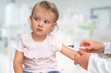 Pediyatrist doktor bebeğe aşı enjekte ediyor. Aşı kavramı.