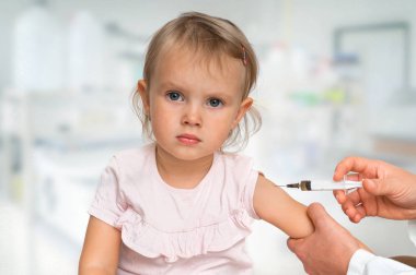 Pediyatrist doktor bebeğe aşı enjekte ediyor. Aşı kavramı.