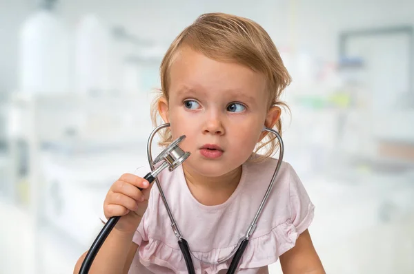 小さな赤ちゃんの手で聴診器で医者を果たしています — ストック写真