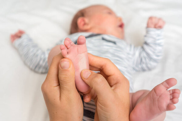 Mother makes foot massage with oil for her baby