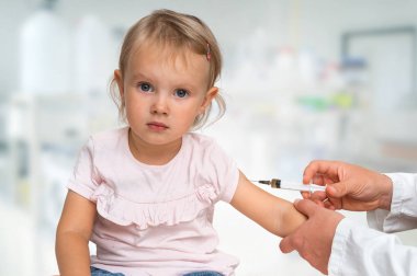 Pediyatrist doktor bebeğe aşı enjekte ediyor. Aşı kavramı.