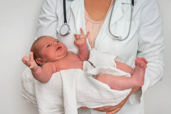 使用听诊器的儿科医生将新生儿抱在怀里 — 图库照片