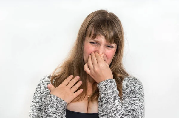 漂亮的女人拿着她的鼻子 难闻的气味概念 — 图库照片