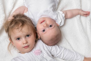 Mutlu gülümseyen kız beyaz battaniye var üzerinde yalan