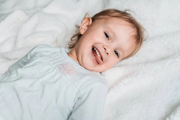 Criança Sorridente Feliz Está Deitada Costas Cobertor Branco Estilo Retro — Fotografia de Stock