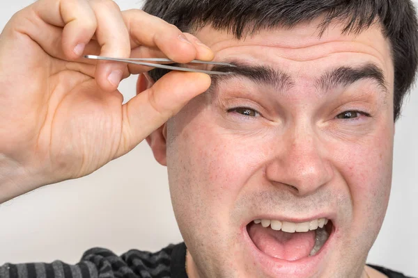 Joven Hombre Está Arrancando Cejas Con Pinzas — Foto de Stock