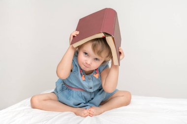 Sevimli küçük çocuk mavi elbiseli bir kitap okuma