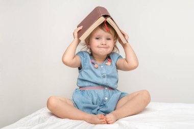 Sevimli küçük çocuk mavi elbiseli bir kitap okuma