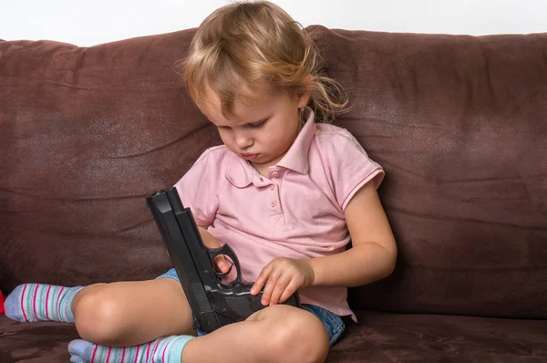 Criança está brincando com os pais pistola - conceito de segurança — Fotografia de Stock