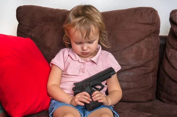 Criança está brincando com pais arma - conceito de segurança — Fotografia de Stock