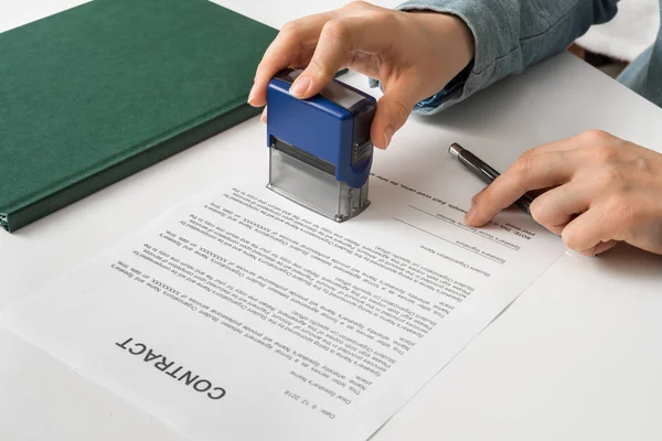 Business woman putting stamp on documents in the office — Stock Photo, Image