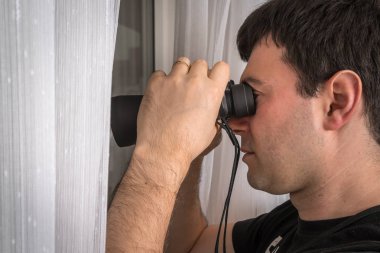 Adam onun komşuları ile dürbün casusluk yapıyor
