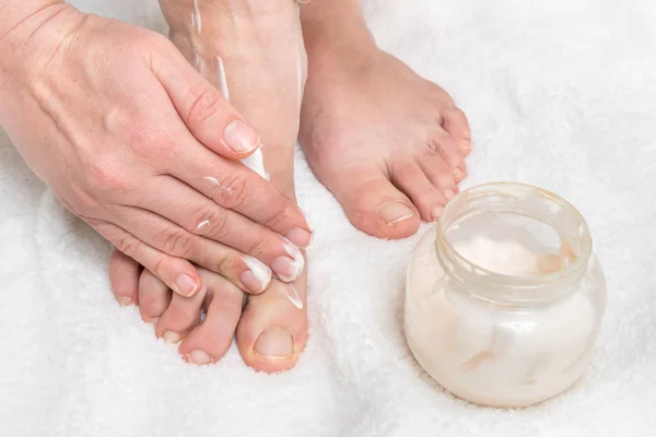 Mujer aplicando crema hidratante en sus pies —  Fotos de Stock