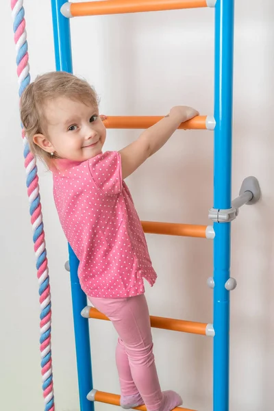 Pequena menina feliz escalando a escada — Fotografia de Stock