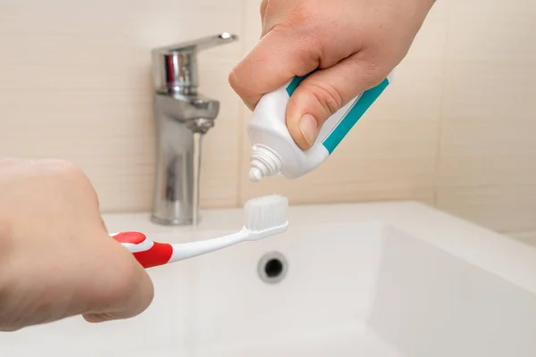 Extrusion of toothpaste on the brush in the bathroom — Stock Photo, Image